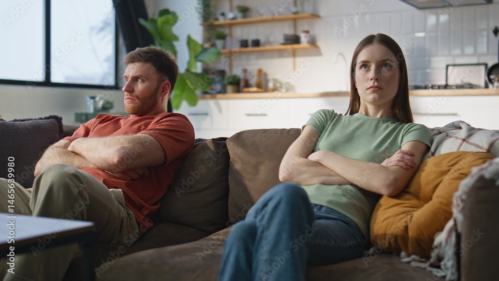 Married couple resent sitting separately home couch closeup. Frustrated partners
