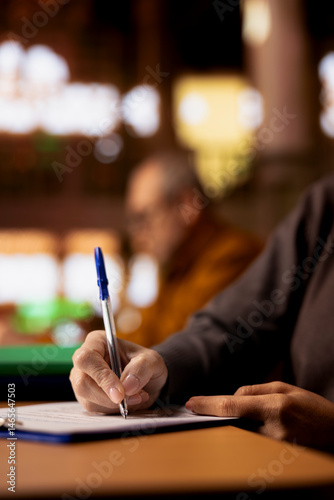 Obraz na płótnie Mature academic person prepares documents for her university coursework, transcribing from literature and textbooks. Scholar focused on research and education in a public library. Close up. w salonie