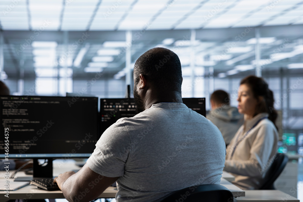 Worker programming in server room housing advanced equipment storing massive datasets. Technician typing code on PC to mend data center racks doing complex computational operations