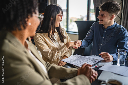 young caucasian and japanese entrepreneur shake hands