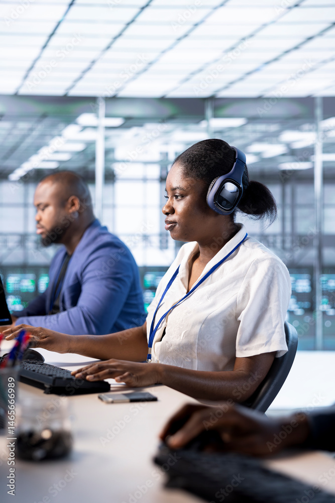 Woman in data center wearing headphones, running system diagnostic tests on PC. Worker listening music, deploying and error checking utilities on computer to fix network issues performance