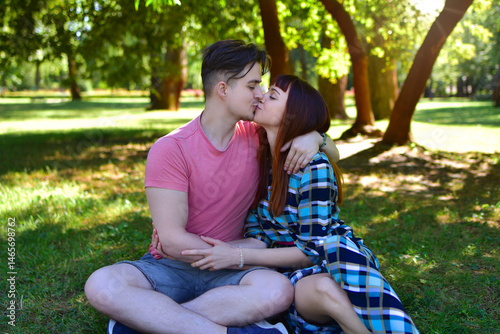 Young Romantic Couple Kissing Outdoors in Sunny Park