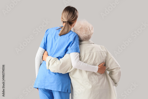 Senior woman with nurse hug...