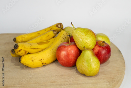 close-up of assorted fruits on a chopping board on a white background
