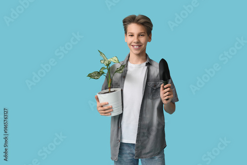Teenage boy with plant and ...