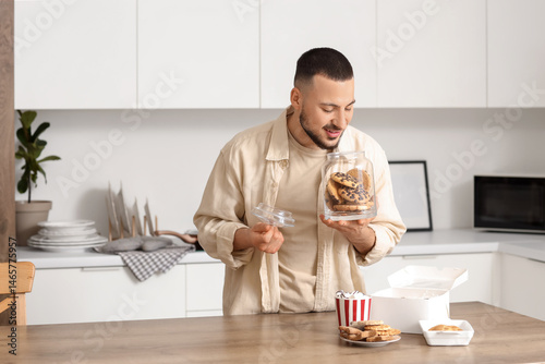Young man with open jar of ...