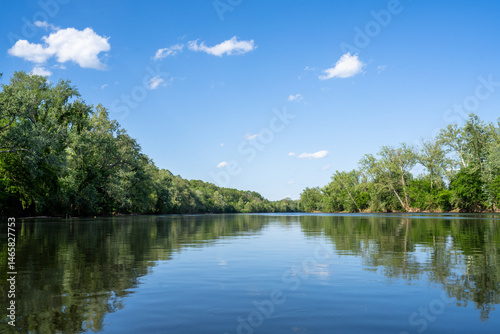 In the Middle of a Calm James River with the Reflection of the Sky and Trees Lining the Riverbank