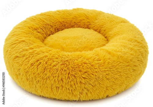 A fluffy yellow pet bed with a circular design isolated on a white background in a studio shot