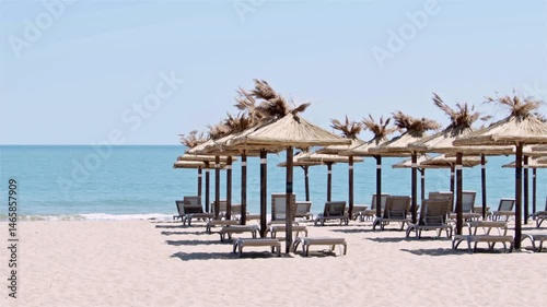 Empty Wooden Umbrellas on Ocean Beach in Early Morning in Summer Footage.