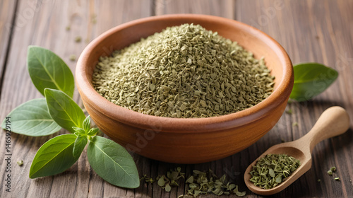 Dried oregano spice on a wooden background. Heap of oregano in a clay bowl.