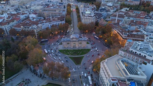 Breathtaking drone shots showcasing the iconic Puerta de Alcal in Madrid during sunset, with vibrant city life surrounding the landmark
