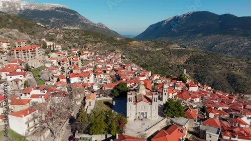 Church of Agios Georgios reveals Arachova mountain town uphill houses, cobbled streets, Viotia, Establishing drone shot