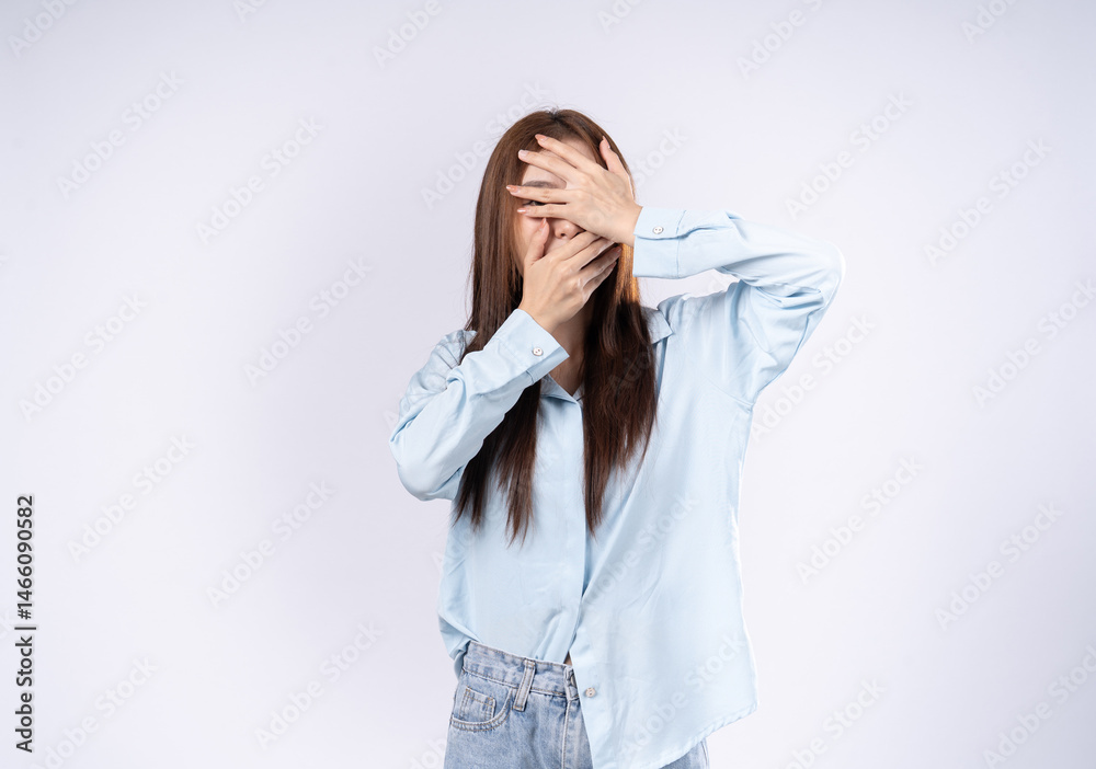 A woman covers her face with her hands in fear, has anxiety in her eyes and panics, has a hidden feeling, her hands cover her face showing fear. A woman covers her face with her hands in fear, has anxiety in her eyes and panics, has a hidden feeling, her hands cover her face showing fear.