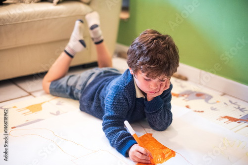 Child engaged in creative drawing on the floor