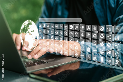 A businessman using a computer with a globe and various icons, representing environmental concepts, green business investment, environmental analysis, awareness, and a strong focus on climate change.