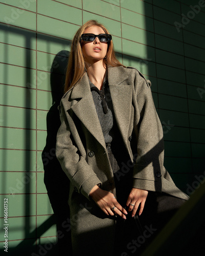 Striking pose by a female model in stylish coat under dramatic lighting