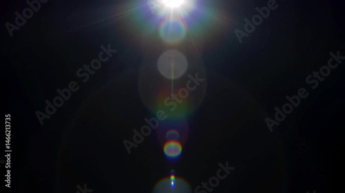 Vertical lens flare of rainbow hues passing slowly from bottom to top across a solid black screen