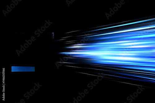 Glowing blue light streaks on black background representing speed, motion and futuristic technology

