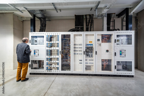 Manager inspecting control panel in industrial production hall