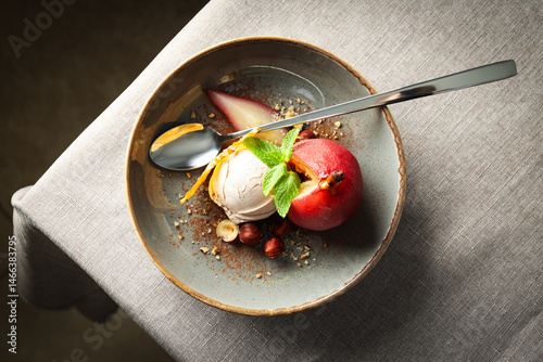 Ice cream and pear in wine on plate and spoon on light background, top view
