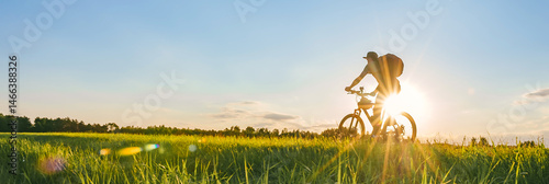 Long banner, man cyclist riding his bike in a field.