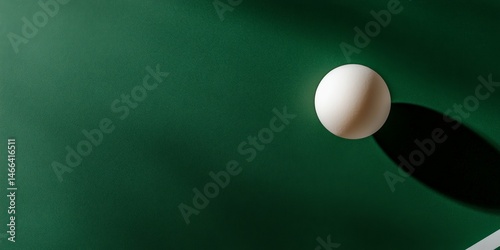 White ball casting shadow on green surface in minimalist design