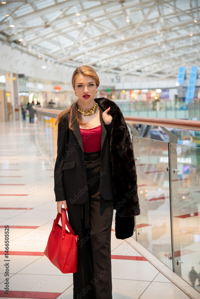Fototapeta premium Woman in stylish outfit enjoys shopping at a modern retail mall