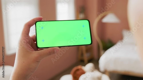 a man is looking at a green screen cellphone