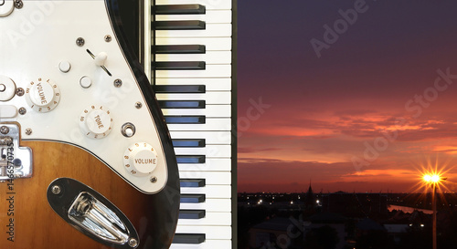 Music party at night with image of guitar and piano keyboard with urban atmosphere of beautiful twilight sky background.