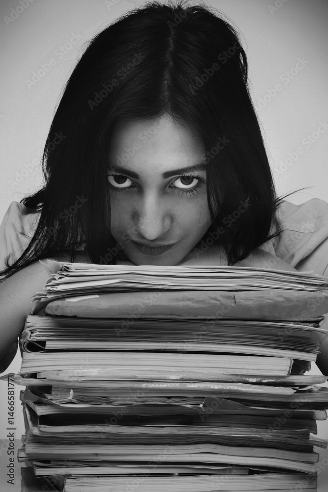 Young beautiful woman is looking over work files. Office work. Black and white image.