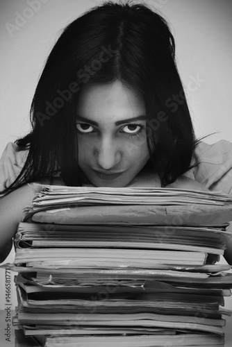 Obraz na płótnie Young beautiful woman is looking over work files. Office work. Black and white image. w salonie