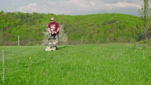 man mowing the lawn in his yard at the country house