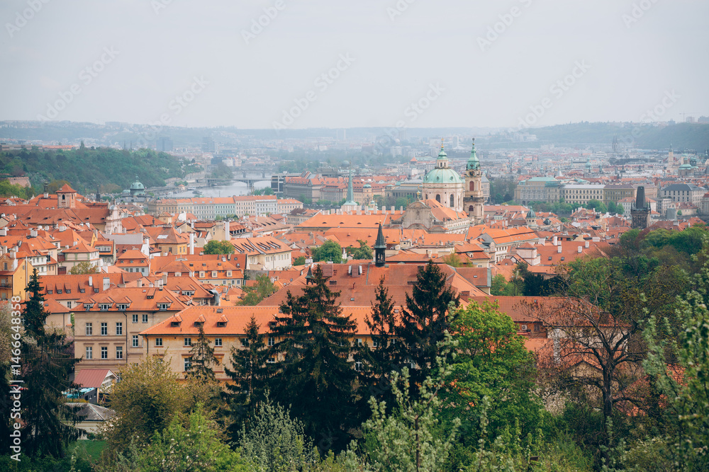 Obraz premium Spring in Prague showcases vibrant rooftops and lush greenery that highlight the beauty of the cityscape