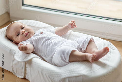 Foto Baby resting in soft white baby lounger