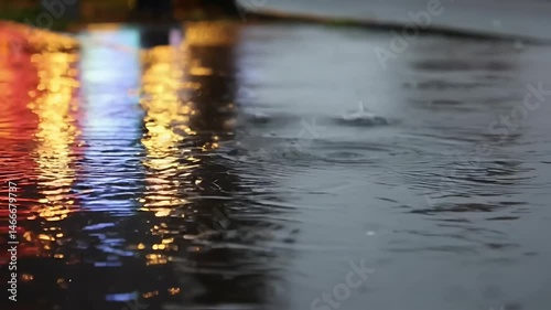 Raindrops Creating Ripples on a Puddle – Soft City Light Reflections and Calm Melancholic Ambiance