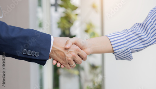 close up investor businessman handshake with businesswoman partner after finishing agreement or deal for financial cooperative concept