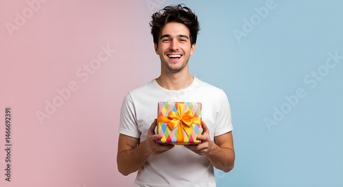 Happy young man holding a gift with a cheerful smile