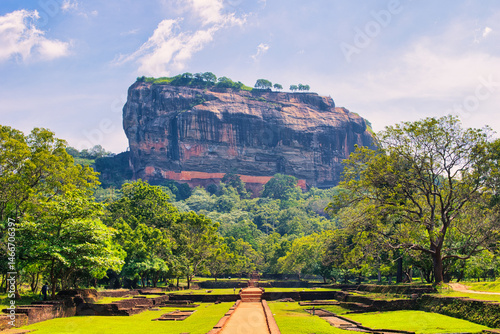 SIGIRIYA, SRI LANKA - JANUARY 20, 2022: Unidentified tourists climb Sigiriya Lion rock fortress in Sigiriya, Sri Lanka. Sigiriya is listed as UNESCO World Heritage Site. On hot sunny day.