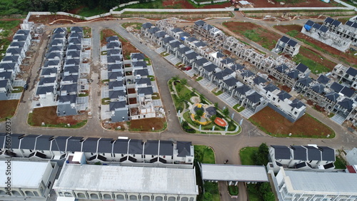 A picturesque aerial view showcases a newly developed residential area, with rows of modern houses arranged in an organized layout