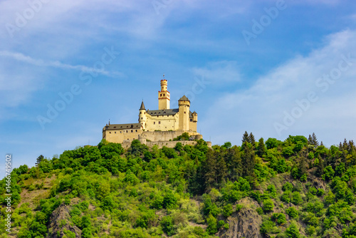 Close-up view of yellow Marksburg (Marks Castle) on the hill with vibrant green forest in Braubach, Germany