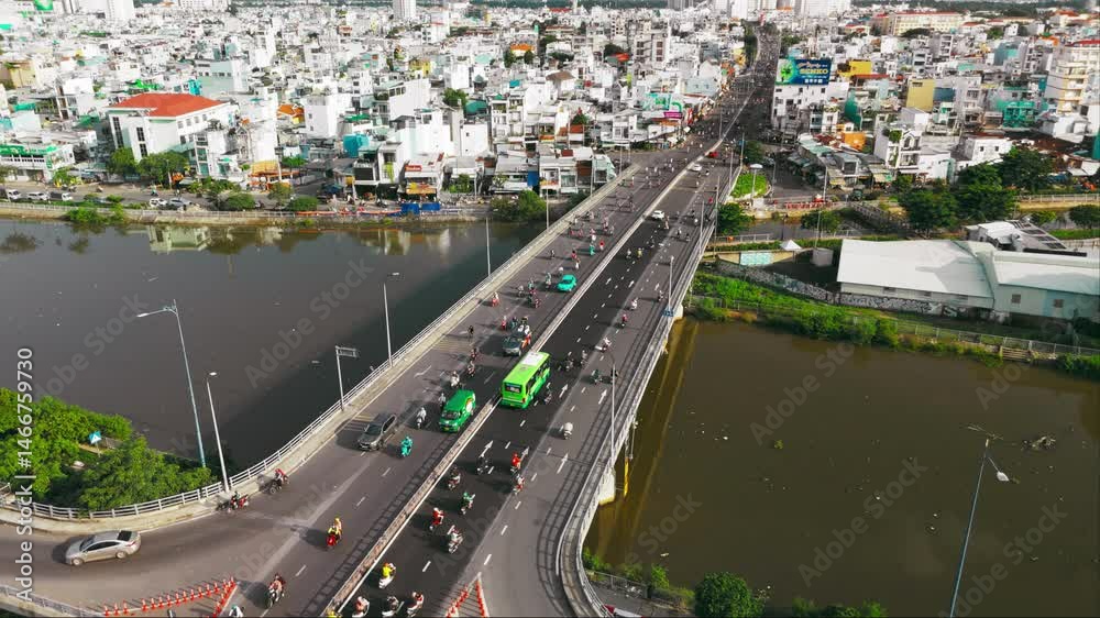 Soar over a bustling city bridge during rush hour in this drone stock video. Dynamic traffic flow and urban energy pulse under vibrant twilight skies