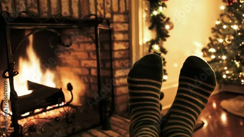 Cozy feet enjoying a warm fireplace during Christmas season  