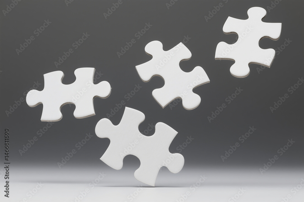 © Hasan Creatives - Four white puzzle pieces isolated against a gradient gray backdrop representing problem solving