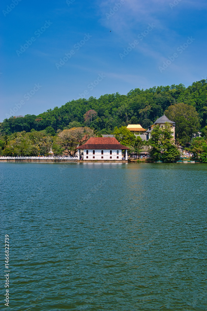 Fototapeta premium KANDY, SRI LANKA - FEBRUARY 10, 2021: View on Kandy lake and big Buddha on top of the hill. Kandy is home of The Temple of the Tooth Relic, one of the most sacred Buddhist places of worship. 