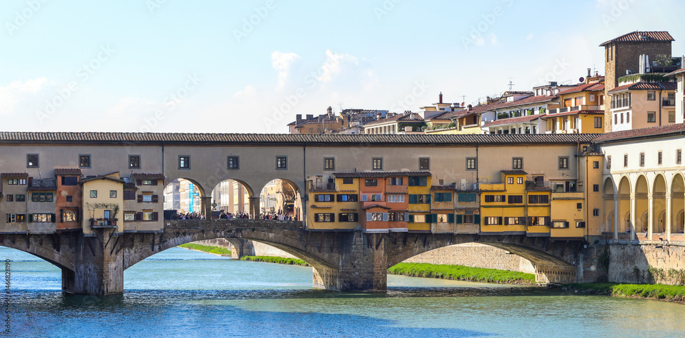 Fototapeta premium Ponte Vecchio spanning Arno River with colorful shops in Florence