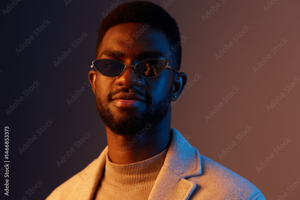 Stylish young man in sunglasses wearing a beige turtleneck and a light gray coat, showing confidence against a gradient background, trendy fashion concept Stylish young man in sunglasses wearing a beige turtleneck and a light gray coat, showing confidence against a gradient background, trendy fashion concept