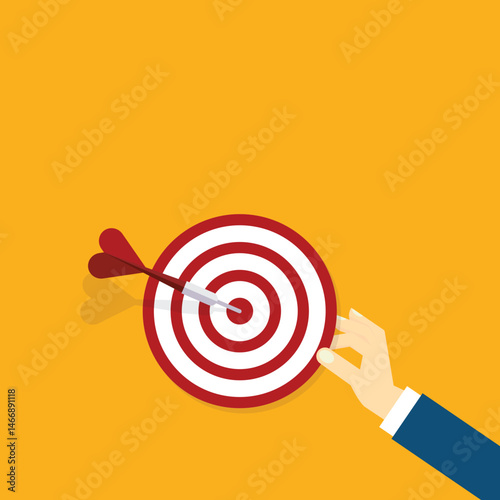 Hand holding a target, showing a goal. Red arrow hits the center. Business challenge failure and success concept.