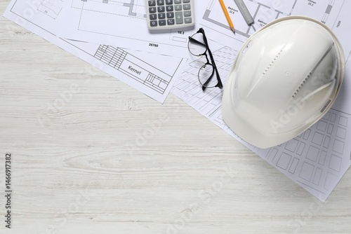 Different architectural drawings, hard hat, pencil, vernier caliper, calculator and glasses on light wooden table, flat lay. Space for text