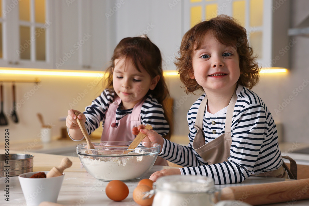 Cooking recipe. Cute children making dough for cookies at table in kitchen Cooking recipe. Cute children making dough for cookies at table in kitchen