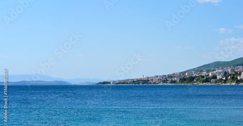 Obraz na płótnie A serene view from Selce across the clear blue sea towards the coastal town of Crikvenica nestled along the green hillside under a bright sky w salonie